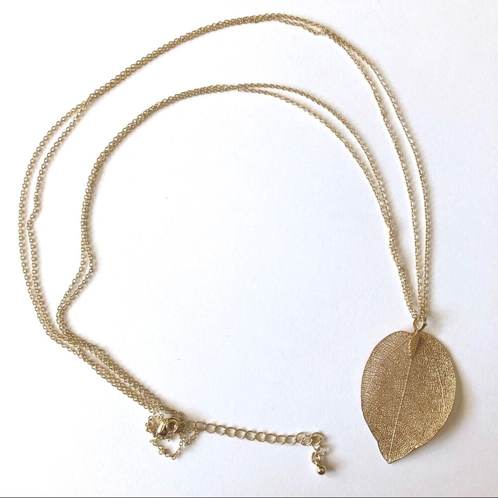 Gold tone double stranded necklace w/leaf pendant